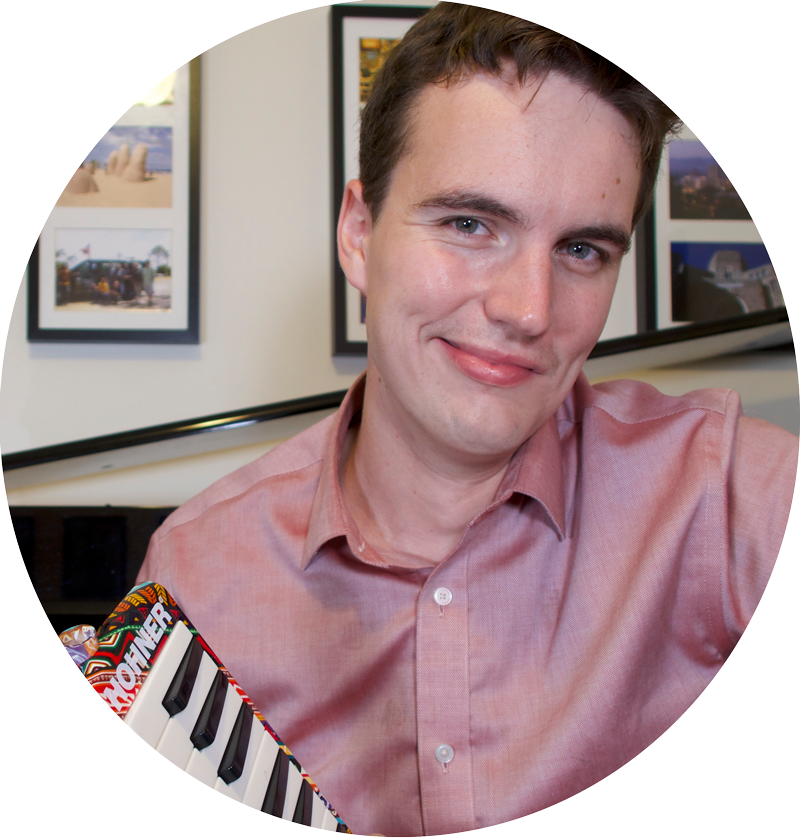 Nick Stubblefield sits at his piano and holds a melodica